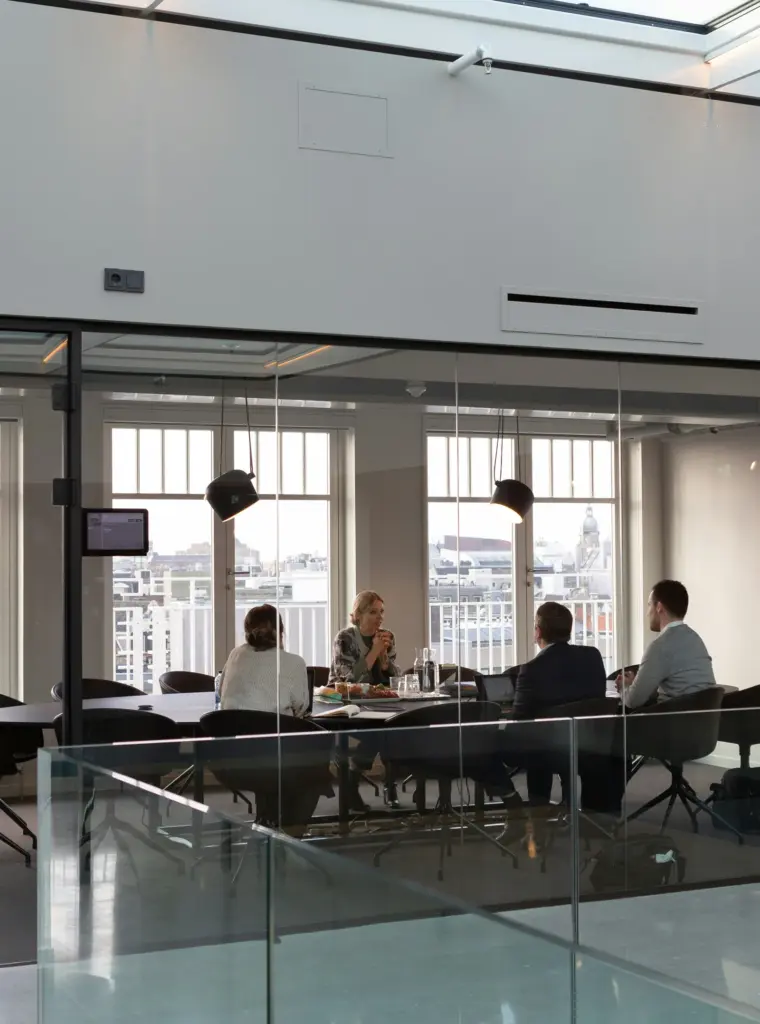 Team meeting in a glass-walled boardroom overlooking the city